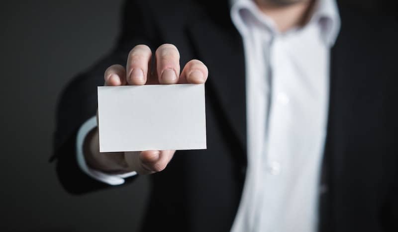 suited person holding a blank card up to the camera to represent identity theft protection