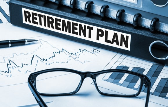 retirement plan written on a stack of papers with black glasses laid on top